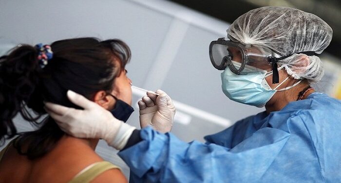 A healthcare worker takes a swab sample from a woman to be tested for the coronavirus disease (COVID-19), at a bus terminal  in Buenos Aires, Argentina January 12, 2021. REUTERS/Agustin Marcarian - RC2H6L9JU10A