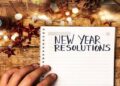 Person writing new year resolutions first person view