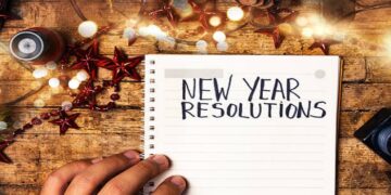 Person writing new year resolutions first person view