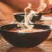 Hot vegetable soup in a dish made of natural materials. Traditional family lunch in a Russian village